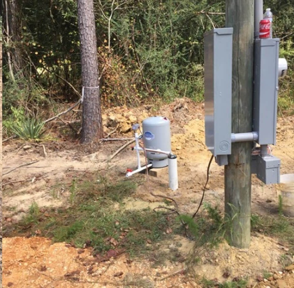 A finished H&P Wells pressure tank and electrical service at a rural wellhead