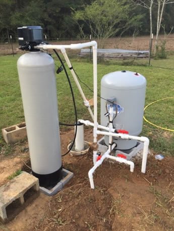 Water softener and pressure tank installed at a pasture wellhead